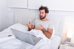 Man lying in bed on virtual call